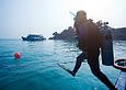 An expedition volunteer in the Philippines enters the water to collect valuable scientific research data